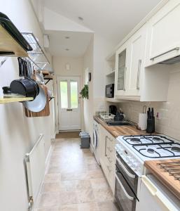 卡迪夫Studio Apartment North Cardiff的厨房配有白色橱柜和炉灶烤箱。