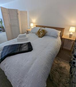 卡迪夫Studio Apartment North Cardiff的一间卧室配有一张带两盏灯的大型白色床。
