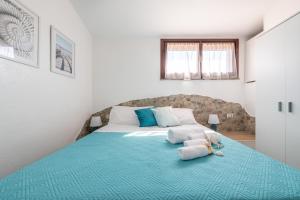 维拉西米乌斯Porto Luna的一间卧室配有一张带蓝色毯子的大床