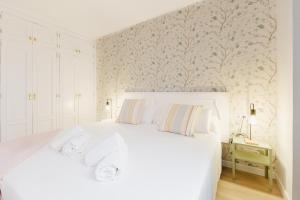 拉克鲁斯Acogedor apartamento en Puerto de la Cruz的卧室配有一张白色大床和墙壁