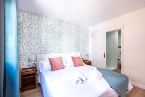 拉克鲁斯Acogedor apartamento en Puerto de la Cruz的卧室配有白色床和粉红色枕头