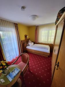 基姆湖畔普林Gästehaus Schwarz的卧室配有1张床、1张桌子和1把椅子