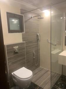 安曼城市玫瑰套房酒店的一间带卫生间和玻璃淋浴间的浴室