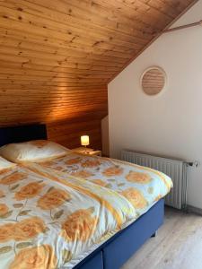 东卡佩勒B&B Oostkapelle aan Zee的卧室内的一张床铺,设有木制天花板