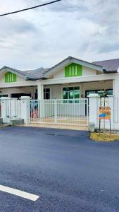 马六甲Homestay Intan Anjung Lodge的前面有栅栏的白色建筑