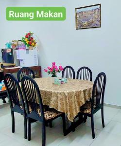 马六甲Homestay Intan Anjung Lodge的餐桌、四把椅子和桌子