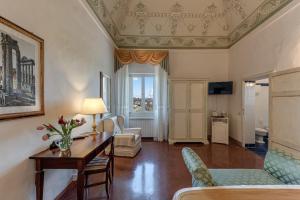 锡耶纳迪瓦里宫酒店的客厅配有桌子和沙发