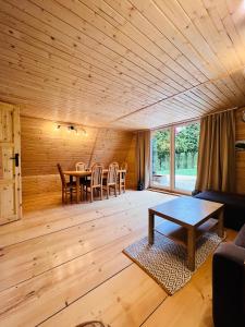 拉伊恰Domek nad Potokiem w Beskidach的客厅设有木制天花板和桌子
