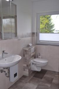 因塞尔波埃尔Haus Simone的一间带水槽和卫生间的浴室以及窗户。