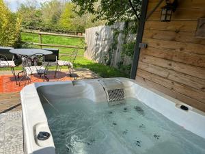 翁弗勒尔Aux murmures de la nature的后院的热水浴池,配有桌椅