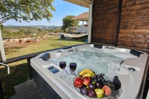 Manot比托诺费度假屋的热水浴池,备有一碗水果和两杯葡萄酒