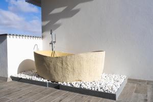 科蒂略LACASA Apartments Cotillo的浴缸,坐在一堆岩石上