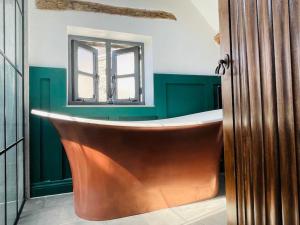 StreteTHE APPLE LOFT - Rustic luxury one bed cottage的带浴缸的浴室和窗户