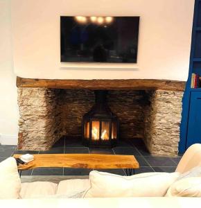StreteTHE APPLE LOFT - Rustic luxury one bed cottage的客厅设有壁炉和平面电视