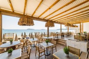 梅加利阿莫斯Skiathos Thalassa Cape, Philian Hotels and Resorts的一间带桌椅的海景餐厅