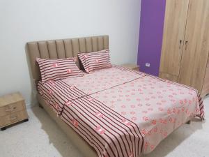 乌姆苏克Djerba La Douce的一张带粉色和白色床单及枕头的床