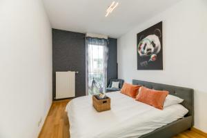 格勒诺布尔Le Bali- Garage- Terrasse- Relaxant- Belle Vue的一间卧室配有带白色床单和橙色枕头的床。
