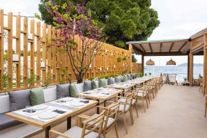 梅加利阿莫斯Skiathos Thalassa Cape, Philian Hotels and Resorts的庭院里一排桌椅