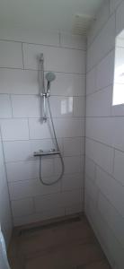 德科赫Logies Plevierstraat的白色瓷砖浴室设有淋浴和窗户