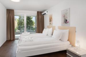 因特拉肯Swiss Hotel Apartments - Interlaken的客厅配有2张白色沙发和窗户