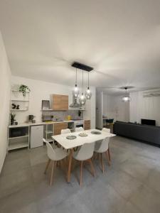 马里诺Cava Home - Castelli Apartments的厨房以及带白色桌椅的用餐室。