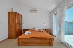 巴什卡沃达Villa Juric的一间卧室设有一张床和一个大窗户