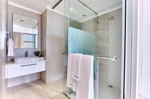约翰内斯堡Executive and Spacious Apartments in Masingita Towers Sandton的一间带玻璃淋浴和水槽的浴室