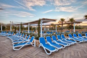 梅利哈db Seabank Resort + Spa All Inclusive的庭院里一排蓝色的躺椅