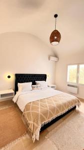 哈马马特Villa a la montagne Hammamet的一间卧室配有一张大床和黑色床头板