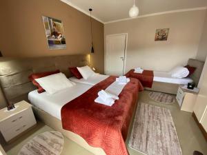 波格拉德茨Guest's Apartament的酒店客房带两张红色和白色的床单