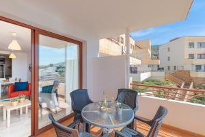 内尔哈Andaluz Apartments Mar de Nerja的阳台的用餐室配有桌椅