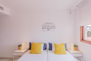 内尔哈Andaluz Apartments Mar de Nerja的客房内的白色沙发,配有黄色枕头