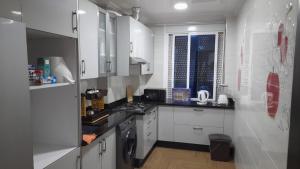 纳祖尔appartement NADOR wifi gratuit的厨房配有白色橱柜和炉灶烤箱。