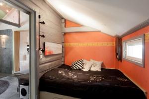 波尔沃Torppa Stengård 1700-luvulta的橙色墙壁的房间里一张小床