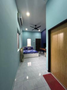 Kampong Ru SepulohMahasa Penarik Homestay的客房设有一张床和一个吊扇。