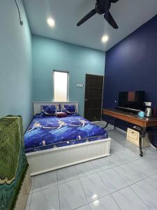 Kampong Ru SepulohMahasa Penarik Homestay的一间卧室配有一张床、一台电视和吊扇