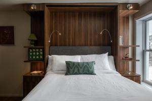 朗斯圣让Maison de Vébron的卧室配有白色床和绿色枕头