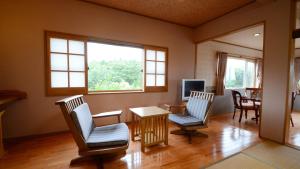 雾岛市Shikisai no Sato Manyu的客厅配有两把椅子和一张桌子