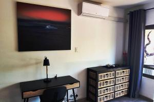 乌姆德洛蒂Modern African surf bachelor unit的一间房间,配有一张桌子和一台墙上的电视
