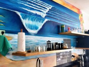 乌姆德洛蒂Modern African surf bachelor unit的厨房墙上挂着一幅波浪画