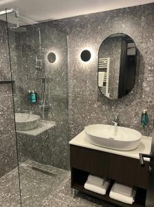 姆西达Park Heights by the Warren Collection的浴室配有盥洗盆和带镜子的淋浴