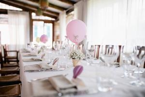 孔韦尔萨诺Casina dei Preti的一张长白桌子,上面有粉红色气球