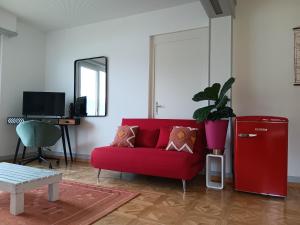 蒙特勒La plus belle vue du lac Léman的客厅里红色的沙发,配有红色的冰箱