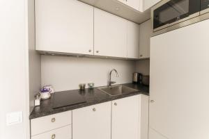 米兹多洛杰Horyzont Apartament z Klimatyzacją i Balkonem by Renters的厨房配有白色橱柜和水槽