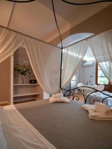 瓦达Locanda dei Sette Limoni的卧室配有一张带白色窗帘的大床