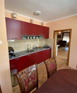 威尔帕扎Green House的厨房配有红色橱柜和桌椅