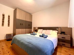 利亚沃尔西Apartament Les 3 Valls的一间卧室配有一张大床,上面有两条蓝色的毛巾