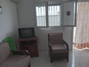 古莱比耶Confortable Maisonnette prés de la plage à Dar el Alouch的客厅配有两把椅子和电视