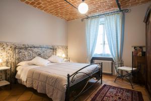 卡拉曼德拉纳La Giribaldina Winery & Farmhouse的一间卧室配有一张带蓝色窗帘的大床
