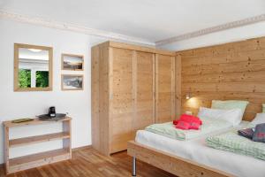加尔米施-帕滕基兴Berghex的一间卧室设有两张床和木墙